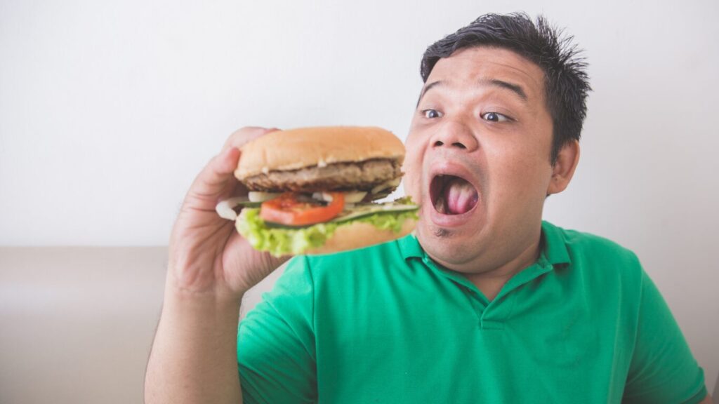 ハンバーガーを食べようとする男性の画像